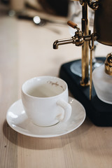 cup of delicious coffee and retro style coffee machine, closeup