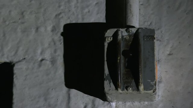 A close up shot of a switch making it look scary by the use of a spot light.