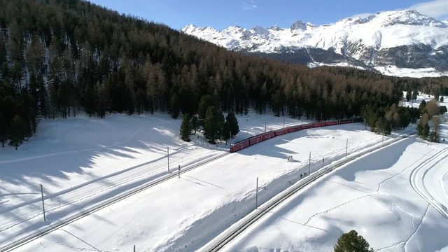 Red train of Bernina, Valley of Engadine. Swiss Alps. Aerial view with drone. Bernina Express
