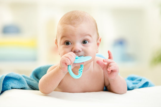 Cute baby with teether toy after bathing