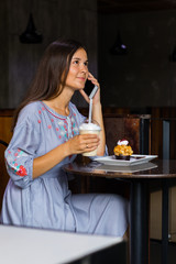 Woman talking with friends by mobile phone in cafe