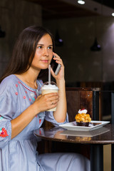 Woman talking with friends by mobile phone in cafe