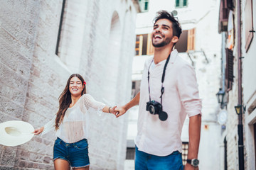 Traveling couple of tourists walking around old town. Vacation, summer, holiday, tourism: concept.