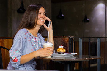Woman talking with friends by mobile phone in cafe