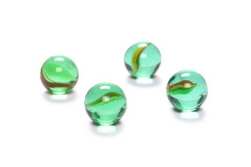 Pile of green glass marbles, isolated on white background