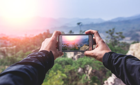 Travel man using smart phone take a photo mountain view