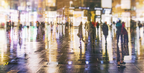 Fototapeta premium people walking on rainy night streets in vienna