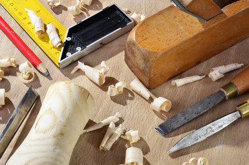 old  carpenter plane tools and wood shavings on wooden background.