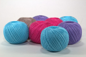 blue, burgundy, purple and brown tangles of natural cotton on a white background in loose form