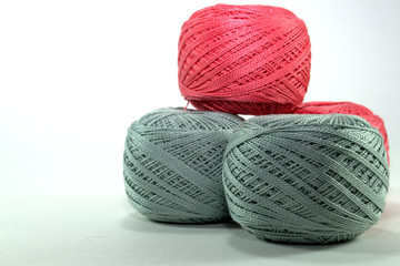 several gray and pink tangles of natural cotton thread on white background