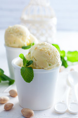 Homemade pistachio ice cream in white cups, selective focus