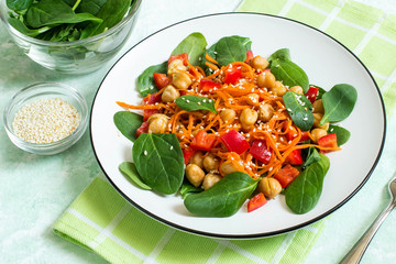 Vegetarian salad with chickpea, carrot, sweet pepper and spinach