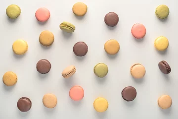 Poster top view of colorful macarons cookies like background, dessert concept © Alisa