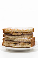 Fototapeta na wymiar sweet sandwich with chocolate paste and banana on white plate, vertical