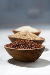 three kinds of dry rice in wooden bowls, vertical