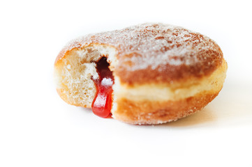 German fried donut, so called Krapfen, Berliner or Pfannkuchen, filled with rose hip jam and dusted with cinnamon sugar, traditionally eaten on carnival or New Year's Eve isolated on white background