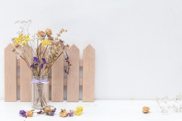 Composition of dried flowers and decoration on white cracked wall background.