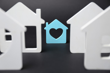 House figures and one different on dark background