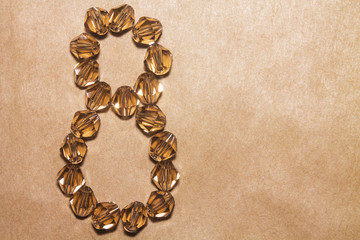 March 8. Numeral eight of the decorative stones on a brown background.