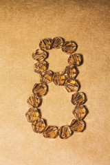 March 8. Numeral eight of the decorative stones on a brown background.