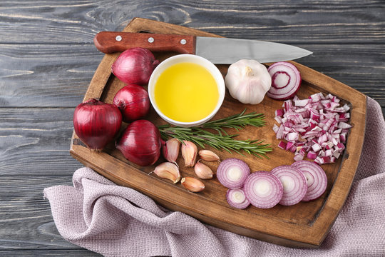 Sliced red onion with garlic on wooden board