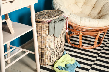 Wicker laundry basket with dirty clothes indoors
