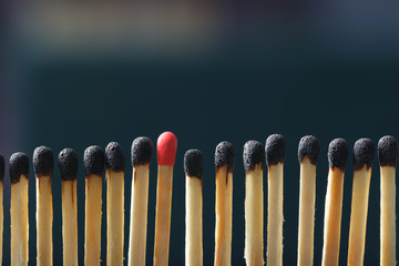 Match standing out from others on dark background. Difference and uniqueness concept