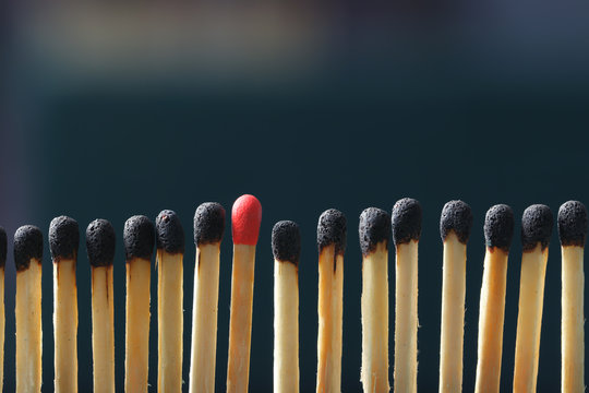 Match standing out from others on dark background. Difference and uniqueness concept