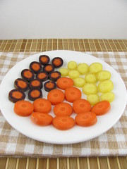 Geschnittene frische bunte Möhrenstücke auf einem Teller