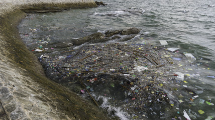 garbage on the baech Beach pollution. Plastic bottles and other trash on sea beach