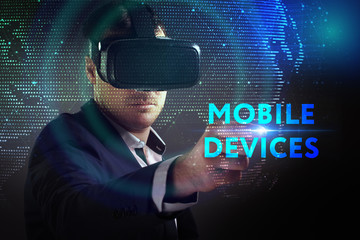 Business, Technology, Internet and network concept. Young businessman working in virtual reality glasses sees the inscription: Mobile devices