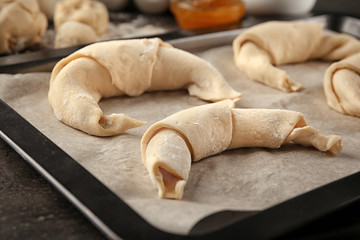 Uncooked croissants on baking sheet, closeup