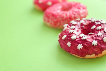 Obraz na płótnie Canvas Delicious donuts on color background