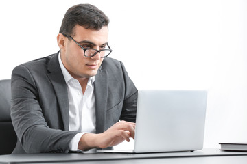 Young man in office wear working with laptop at table