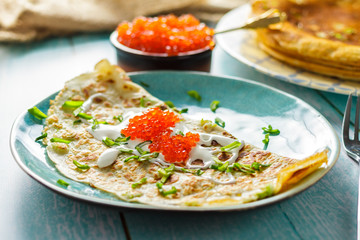 Lush pancakes with green onions, a bank of red caviar. Russian kitchen