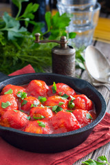 Meatballs in tomato sauce in a cast-iron frying pan, selective focus