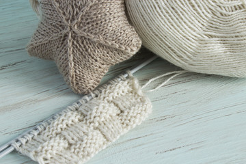 Knitting from light threads on a blue background. Scandinavian style.