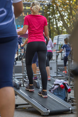 Woman in Sportswear Exercising Outdoor on Treadmill