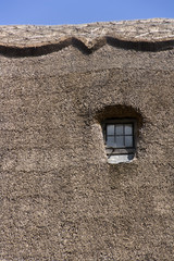 Semi-abstract thatched roof and window