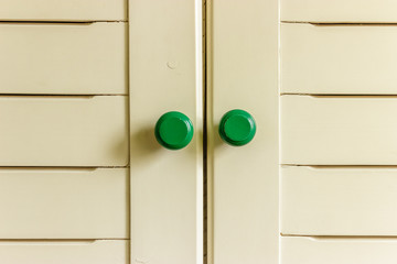 Green roundly handles on white wooden background