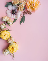 Floral composition of dry roses and anemones, frame on the pink background, top view, flat lay 