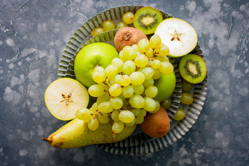 Top view of a healthy food image with fresh fruits (kiwi, apples, pears, bananas, grapes), top view, copy space