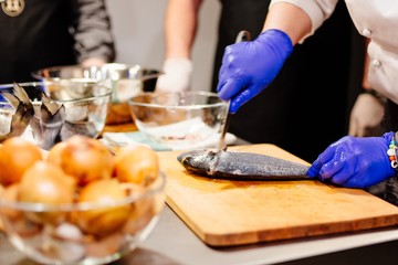 Woman cook preparing and cleaning raw dorada fish