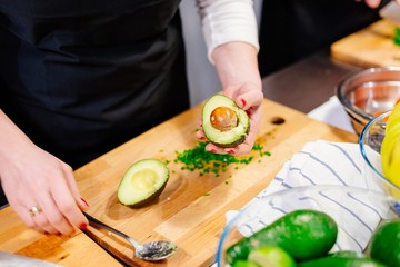 Woman cook opening avocado