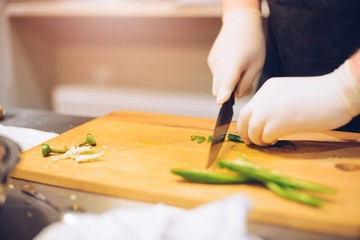 Woman cutting green spicy pepper