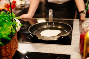 Woman frying tortilla wraps