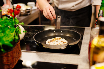 Woman frying tortilla wraps