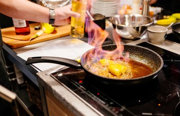 Man frying bananas on frying pan.