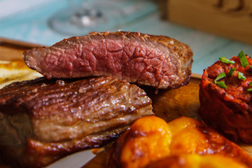 Grilled Medium rare steak Ribeye with green onion on cutting board serving