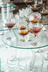 different alcohol drinks on a glass stand. wine, champagne, cognac, vodka, martini
